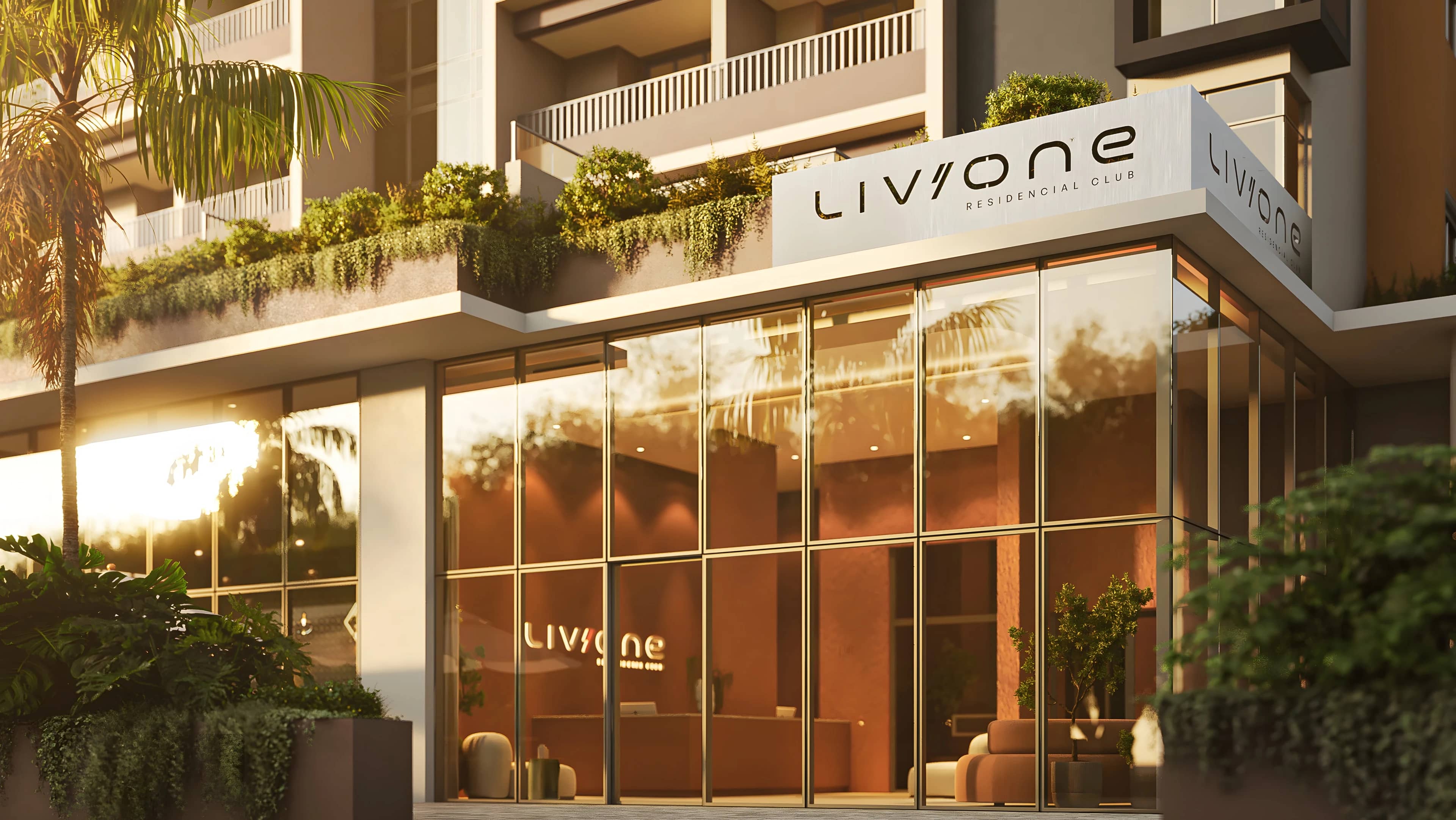 Entrada do Liv One com fachada de vidro, letreiro e jardineiras