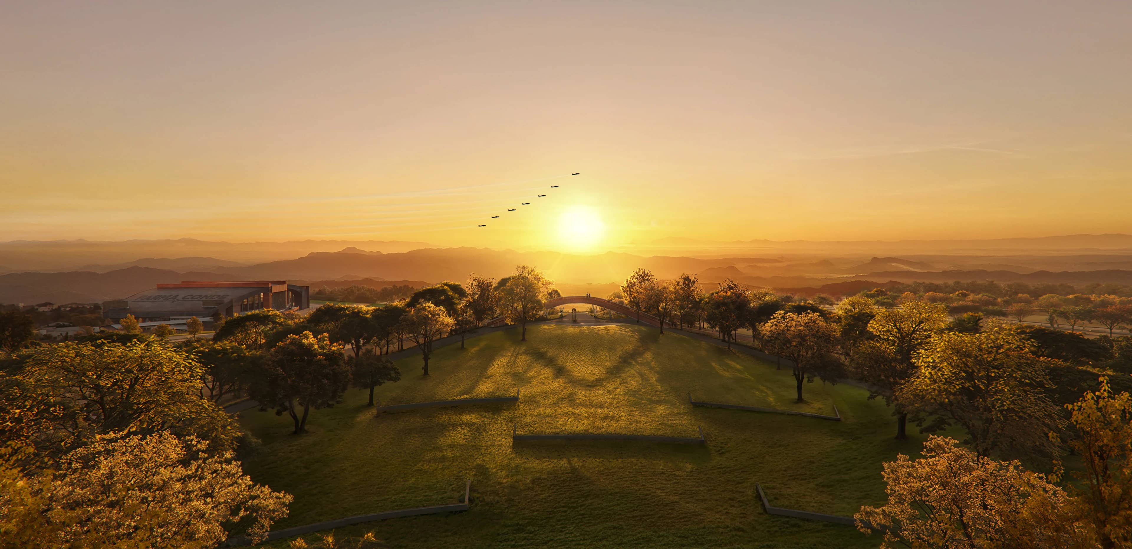 Vista aérea do Parque UNA ao pôr do sol, com a serra ao fundo